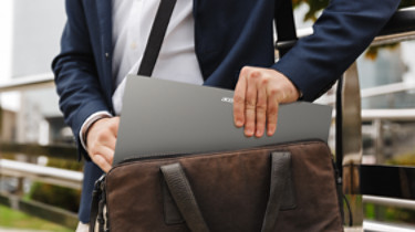 Close up of a man in formal wear taking his laptop out of the bag while standing outdoors; Shutterstock ID 1642917496; purchase_order: -; job: -; client: -; other: -