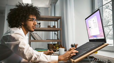 Designer workplace near window. Intelligent creative millennial working with computer on new project. Businessman work from home. Home office concept. Toned image