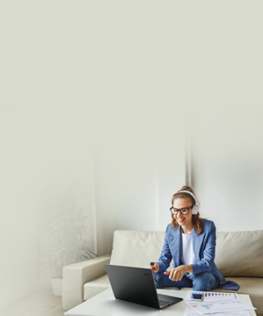 Cheerful young female in casual outfit and glasses having video conversation with colleagues and sharing business ideas while sitting on couch in modern workplace
; Shutterstock ID 1733416808; purchase_order: -; job: -; client: -; other: -