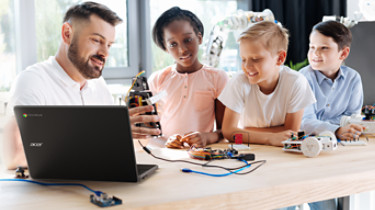 Pleasant robotics specialist conducting a workshop for children; Shutterstock ID 683338096; purchase_order: -; job: -; client: -; other: -