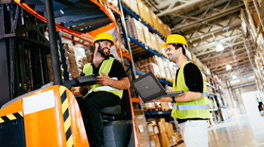 Warehouse workers working together with forklift loader; Shutterstock ID 1390156853; Purchase Order: -